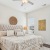 Bedroom with ceiling fan and natural light 